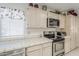 This bright kitchen features white tile countertops and backsplash, and stainless steel appliances at 2629 E Verbena Dr, Phoenix, AZ 85048
