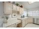 Kitchenette with white cabinets, tile counters, stainless steel sink, and ample natural light at 2629 E Verbena Dr, Phoenix, AZ 85048