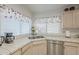 This kitchen sink features a double basin, stainless steel appliances, and window with white blinds at 2629 E Verbena Dr, Phoenix, AZ 85048