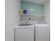 Functional laundry room with washer, dryer, and storage shelf for convenience at 2629 E Verbena Dr, Phoenix, AZ 85048