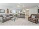 Spacious living room with sofas and a recliner providing ample seating, enhanced by ceiling fans and soft carpet at 2629 E Verbena Dr, Phoenix, AZ 85048
