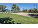 View of a community volleyball court with green grass and trees, perfect for outdoor recreation at 2629 E Verbena Dr, Phoenix, AZ 85048