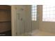 Bathroom featuring tiled shower with glass door, block window, and soaking tub near walk-in closet at 29462 N 126Th Ln, Peoria, AZ 85383