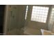 Bathroom featuring a tiled shower with glass door, block window, and large soaking tub at 29462 N 126Th Ln, Peoria, AZ 85383
