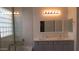 Updated bathroom featuring dual sinks with quartz countertops, tiled shower, and block window at 29462 N 126Th Ln, Peoria, AZ 85383