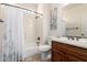Well-lit bathroom with dark wood vanity, tile floor, and a shower-tub combo with white decorative curtain at 32525 N 41St Way, Cave Creek, AZ 85331