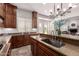 This kitchen boasts wood cabinets, granite countertops, and a stainless steel sink with modern fixtures at 32525 N 41St Way, Cave Creek, AZ 85331