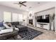 Inviting living room with a cozy fireplace, plush seating, ceiling fan, and a large area rug at 32525 N 41St Way, Cave Creek, AZ 85331