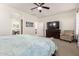 Bright main bedroom with a ceiling fan, TV, chair, and ensuite bathroom entrance at 32525 N 41St Way, Cave Creek, AZ 85331