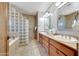 Bathroom features a tub, glass block, granite counters, dual sinks, and custom cabinetry at 36601 N Mule Train Rd # 45B, Carefree, AZ 85377