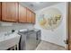 Laundry room with ample storage, modern washer and dryer, sink, and unique cartoon mural adding a touch of fun at 36601 N Mule Train Rd # 45B, Carefree, AZ 85377