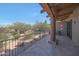 Covered patio with wrought iron railings and views of desert landscaping and native vegetation provides a relaxing outdoor space at 36601 N Mule Train Rd # 45B, Carefree, AZ 85377