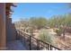 Second story outdoor patio with wrought iron railing with views of desert landscaping, trees and mountains at 36601 N Mule Train Rd # 45B, Carefree, AZ 85377