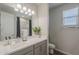 Bathroom featuring a double sink vanity, a large mirror, and a shower with a curtain at 38082 W Santa Barbara Ave, Maricopa, AZ 85138