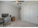 Bedroom with a ceiling fan, closet with sliding doors, and desk with a view at 38082 W Santa Barbara Ave, Maricopa, AZ 85138