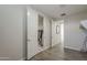 Hallway featuring gray wood-look tile flooring, with open doors leading to closet, and an adjoining room at 38082 W Santa Barbara Ave, Maricopa, AZ 85138