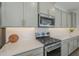 Close up of a stainless steel range, microwave, and subway tile backsplash in a modern kitchen at 38082 W Santa Barbara Ave, Maricopa, AZ 85138