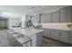 Bright kitchen features stainless steel appliances, a large island with seating, and ample cabinet space at 38082 W Santa Barbara Ave, Maricopa, AZ 85138