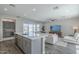 Open floor plan connects kitchen to the living room, with an island and stainless steel appliances at 38082 W Santa Barbara Ave, Maricopa, AZ 85138