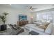 Bright living room features neutral tones, stylish furniture, and a modern ceiling fan at 38082 W Santa Barbara Ave, Maricopa, AZ 85138