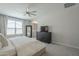 Bright main bedroom with a ceiling fan, dresser with TV, a large window, and a comfortable bed with white bedding at 38082 W Santa Barbara Ave, Maricopa, AZ 85138