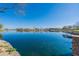 Scenic view of the serene pond surrounded by landscaping, enhancing the community's natural beauty at 38082 W Santa Barbara Ave, Maricopa, AZ 85138