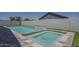 Luxury pool and spa with rock waterfall feature and custom stone surround at 38082 W Santa Barbara Ave, Maricopa, AZ 85138