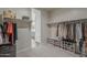 Walk-in closet featuring carpeted flooring, clothing racks and shelving units, and views of the bathroom at 38082 W Santa Barbara Ave, Maricopa, AZ 85138