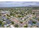 Expansive aerial shot of homes featuring pools and a verdant neighborhood, set against a mountain range backdrop at 3834 E Clarendon Ave, Phoenix, AZ 85018