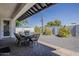 Covered patio with outdoor dining set, gravel groundcover, and decorative trees create outdoor entertaining space at 3834 E Clarendon Ave, Phoenix, AZ 85018