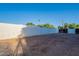 A spacious backyard featuring a white privacy wall and a gravel ground cover at 3834 E Clarendon Ave, Phoenix, AZ 85018