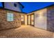 Backyard with brick wall, pavers, two doors, an exterior light, and a window overlooking the patio area at 3834 E Clarendon Ave, Phoenix, AZ 85018