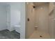 Bathroom featuring a shower with white tile, modern fixtures, and wood-look floors at 3834 E Clarendon Ave, Phoenix, AZ 85018