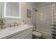 Bathroom with a tiled shower and modern sink with a large, lighted mirror above the white vanity at 3834 E Clarendon Ave, Phoenix, AZ 85018