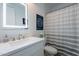 Modern bathroom featuring a vanity with lighted mirror and a shower-tub combo at 3834 E Clarendon Ave, Phoenix, AZ 85018