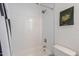 Bathtub and shower with white tile surround, featuring modern shower head, and a toilet in the bathroom at 3834 E Clarendon Ave, Phoenix, AZ 85018