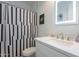 Modern bathroom featuring a vanity with a framed mirror, bright white quartz countertop, and shower with tile surround at 3834 E Clarendon Ave, Phoenix, AZ 85018