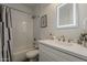 Bathroom with a tiled shower and modern sink with a large, lighted mirror above the white vanity at 3834 E Clarendon Ave, Phoenix, AZ 85018