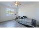 Bright bedroom featuring a ceiling fan, light gray wood-look floors, a large window, and a modern bed at 3834 E Clarendon Ave, Phoenix, AZ 85018