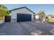 Wide brick driveway leading to a modern home with a spacious two-car garage at 3834 E Clarendon Ave, Phoenix, AZ 85018
