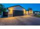 Beautiful house exterior at dusk showcasing brick accents, lush lawn, and a long driveway at 3834 E Clarendon Ave, Phoenix, AZ 85018