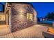 Stunning brick exterior with stylish outdoor lighting, leading to a cozy brick patio with a modern fire pit at 3834 E Clarendon Ave, Phoenix, AZ 85018