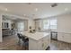 Bright kitchen featuring an island with seating, white cabinets, stainless steel appliances, and views to the living space at 3834 E Clarendon Ave, Phoenix, AZ 85018