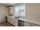 Bright kitchen features white cabinets, subway tile backsplash, quartz countertops, and a window with a view to the backyard at 3834 E Clarendon Ave, Phoenix, AZ 85018