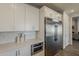 This kitchen features white cabinetry, stainless steel appliances, and a view into the main living space at 3834 E Clarendon Ave, Phoenix, AZ 85018
