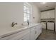 Well-lit laundry room with white cabinets, modern appliances, and stone countertops at 3834 E Clarendon Ave, Phoenix, AZ 85018