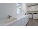 Functional laundry room with a sink, quartz countertop and a stacked washer and dryer at 3834 E Clarendon Ave, Phoenix, AZ 85018
