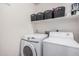 Functional laundry room featuring a washer, dryer, and shelving for storage at 4117 E Baylor Ln, Gilbert, AZ 85296