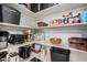 Walk-in pantry with white shelving stocked with food, containers and small appliances at 4117 E Baylor Ln, Gilbert, AZ 85296