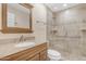 Bathroom with granite vanity, framed mirror and glass enclosed shower at 4200 N Miller Rd # 112, Scottsdale, AZ 85251
